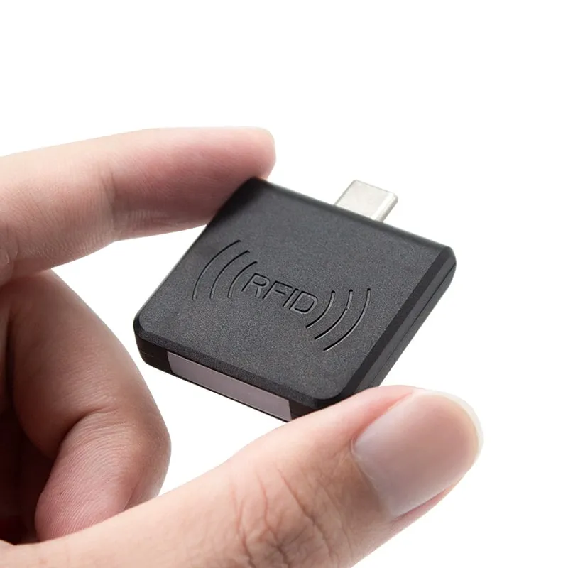 H220-C black plug-in NFC reader held between two fingers to show its size